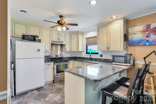 a kitchen with stainless steel appliances granite countertop a stove a refrigerator and a sink