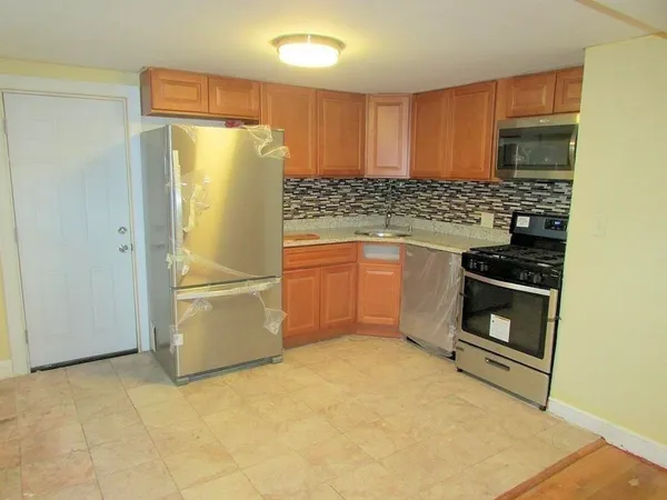 a kitchen with granite countertop a refrigerator and a stove top oven