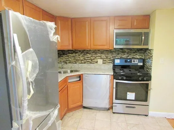 a kitchen with stainless steel appliances granite countertop a refrigerator and a stove
