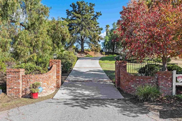 a front view of a house with a yard and potted plants