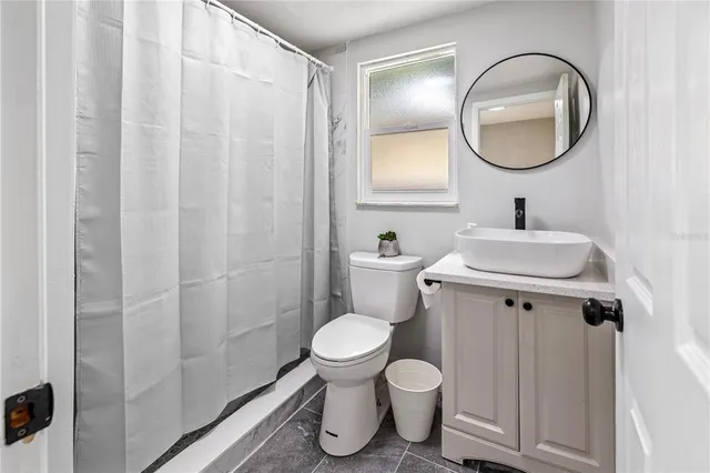 a bathroom with a toilet sink vanity and mirror