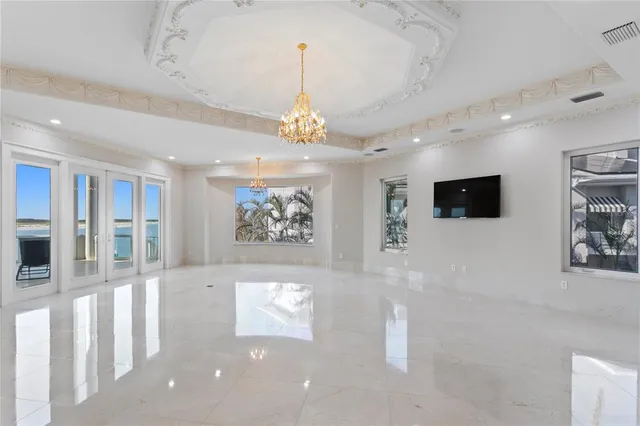 a view of an empty room with wooden floor and windows