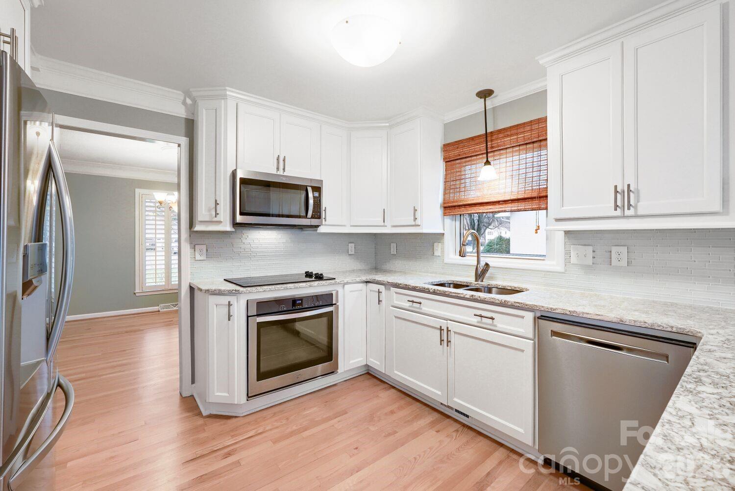 22527 John Gamble Road Cornelius, NC 28031 - Photo 10 of 33 a kitchen with granite countertop a stove top oven and sink