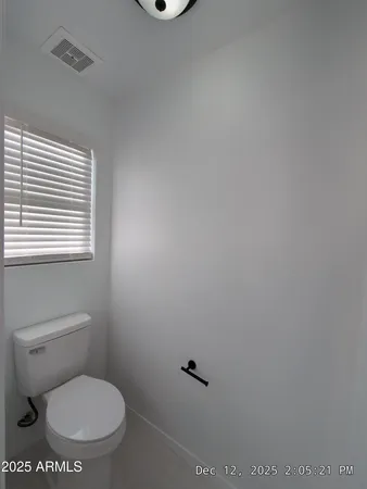 a white toilet sitting next to a window