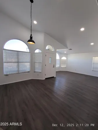 a view of a room with wooden floor and ceiling fan