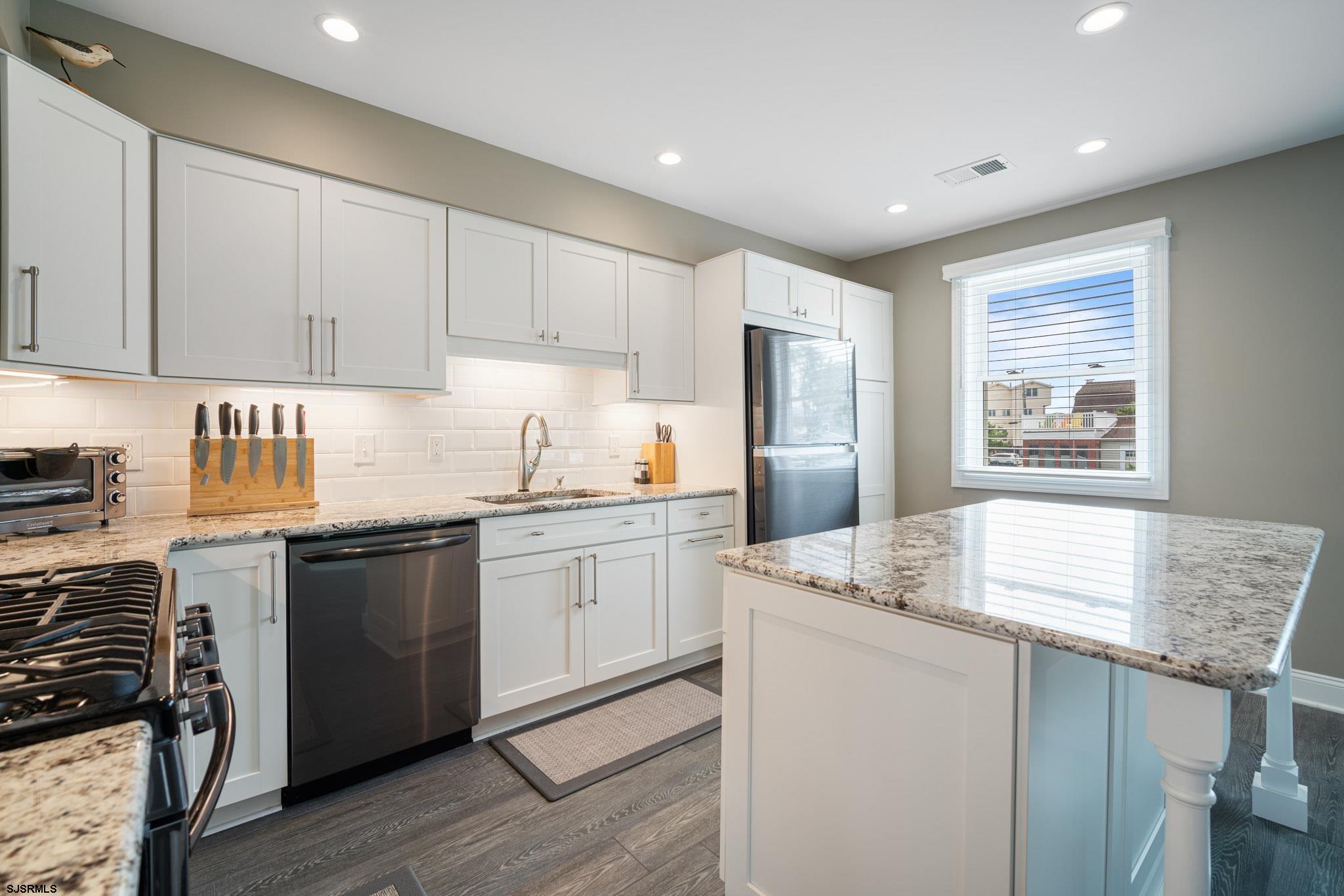 440 Hackney Place Brigantine, NJ 08203 - Photo 21 of 45 a kitchen with granite countertop cabinets stainless steel appliances a sink and a window