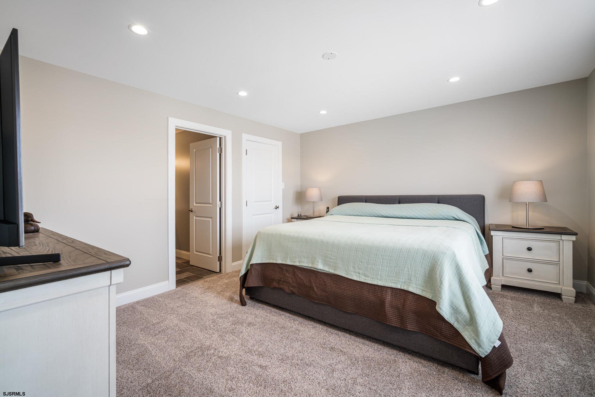 440 Hackney Place Brigantine, NJ 08203 - Photo 27 of 45 a spacious bedroom with a bed and a flat screen tv