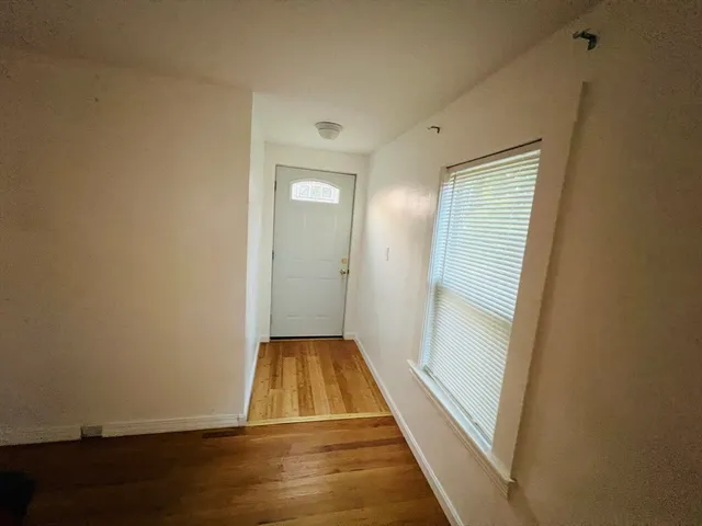 a view of a room with wooden floor and window