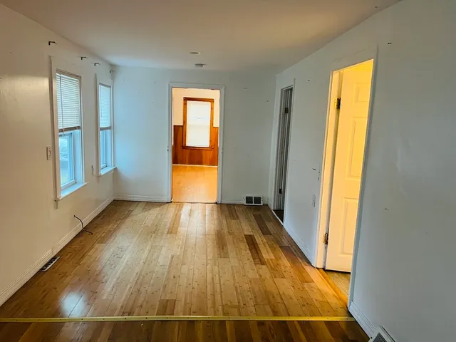 a view of a room with wooden floor and door