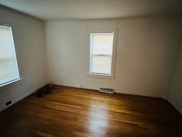 a view of a room with wooden floor and window