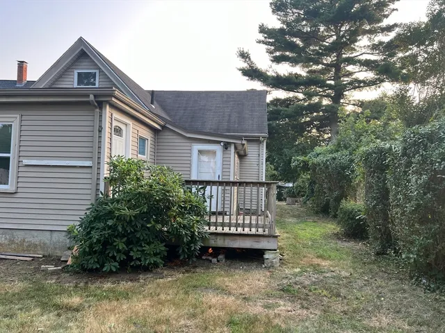a view of a house with a small yard and wooden fence