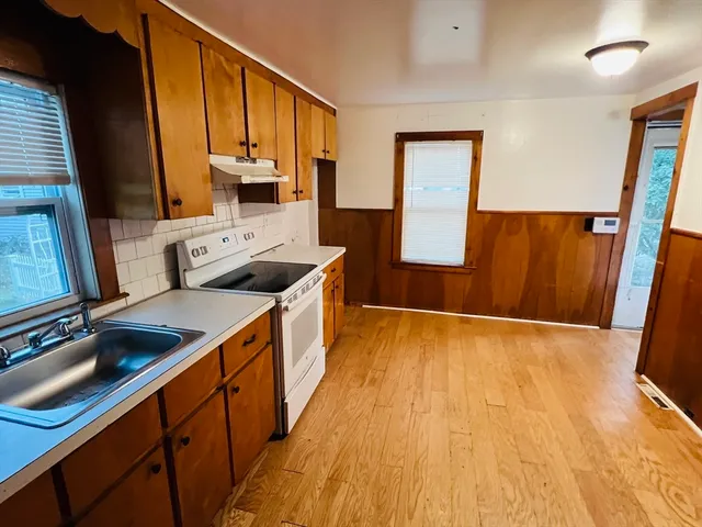 a kitchen with stainless steel appliances granite countertop a sink stove and wooden floor