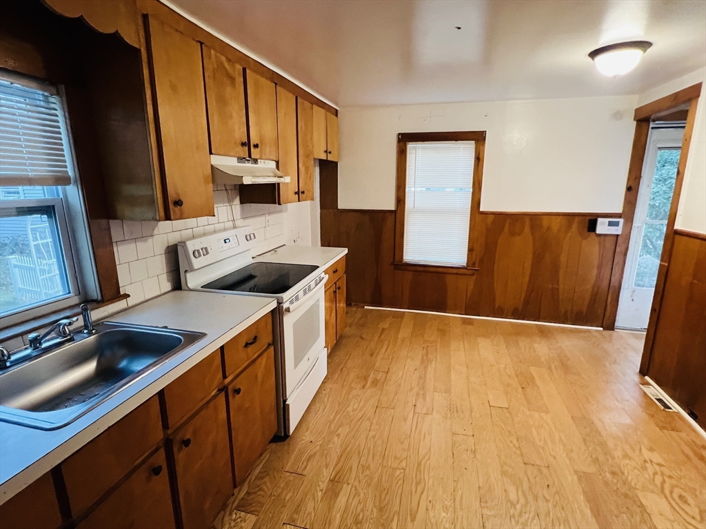 61 East Main Street Brockton, MA 02301 - Photo 7 of 20 a kitchen with stainless steel appliances granite countertop a sink stove and wooden floor