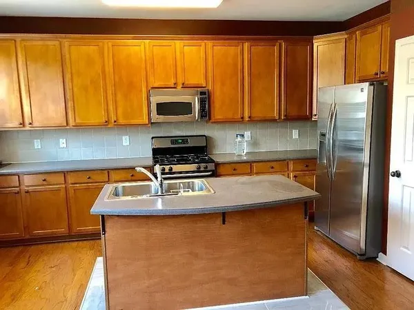 a kitchen with stainless steel appliances granite countertop a refrigerator a stove top oven a sink and dishwasher