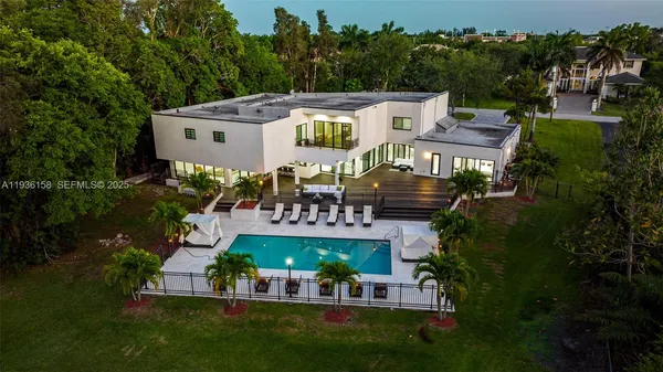 an aerial view of a house with a yard potted plants and large tree