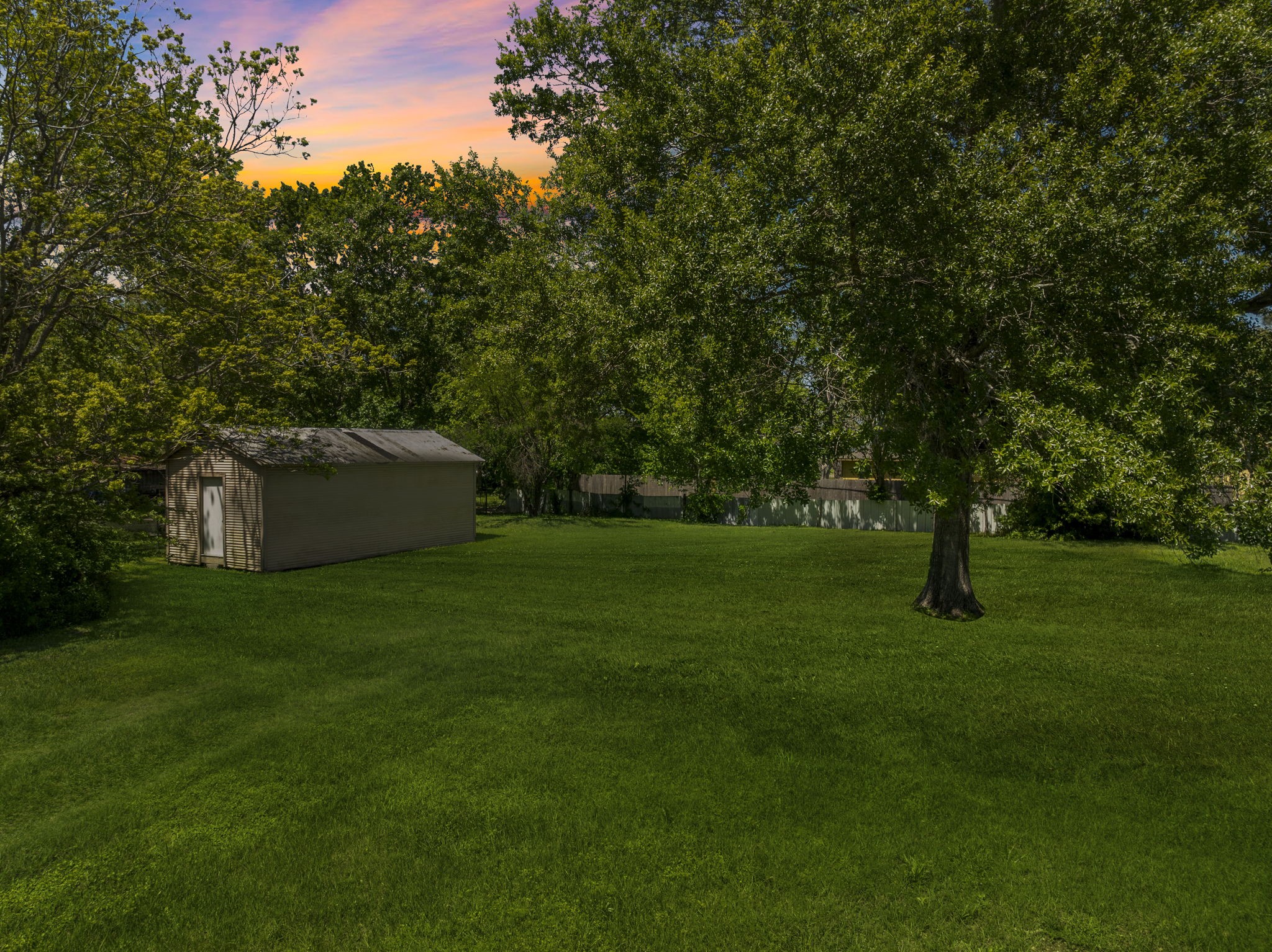 903 Brooks Avenue Rosenberg, TX 77471 - Photo 4 of 11 A flat, open terrain framed by mature shade trees and a small storage structure adds both function and charm to this ready-to-develop property.