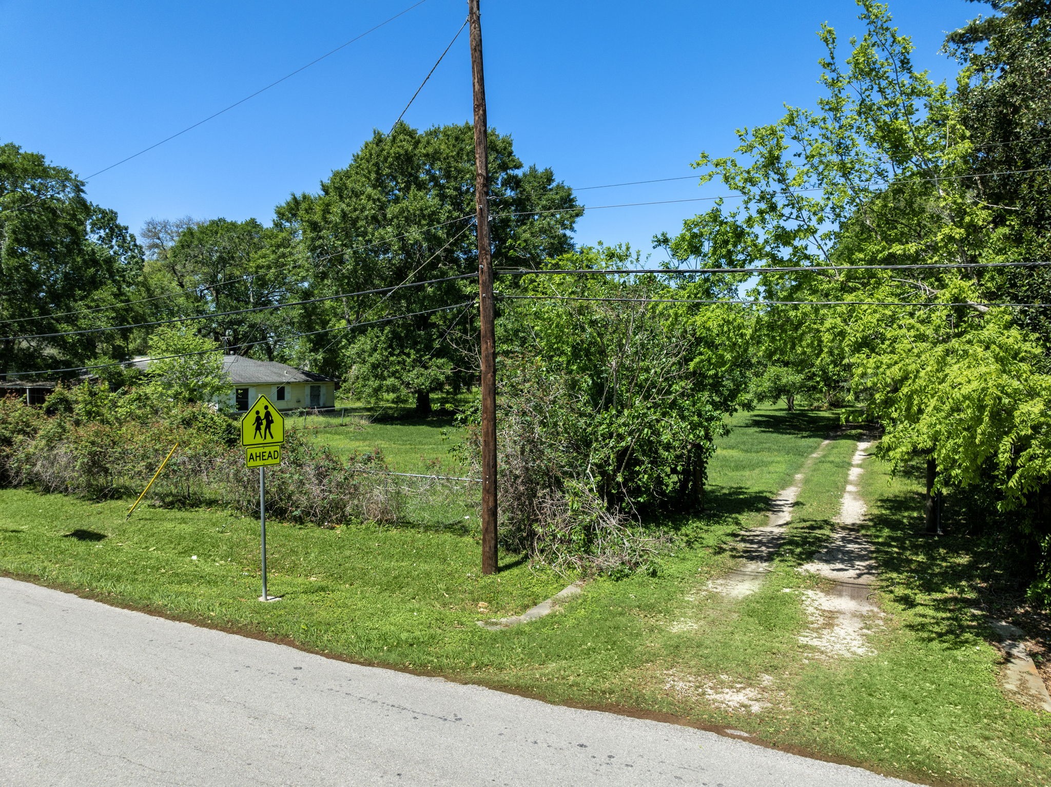 903 Brooks Avenue Rosenberg, TX 77471 - Photo 5 of 11 An open entrance with a visible path connects the lot to the street, offering direct access for future site development or construction activity.