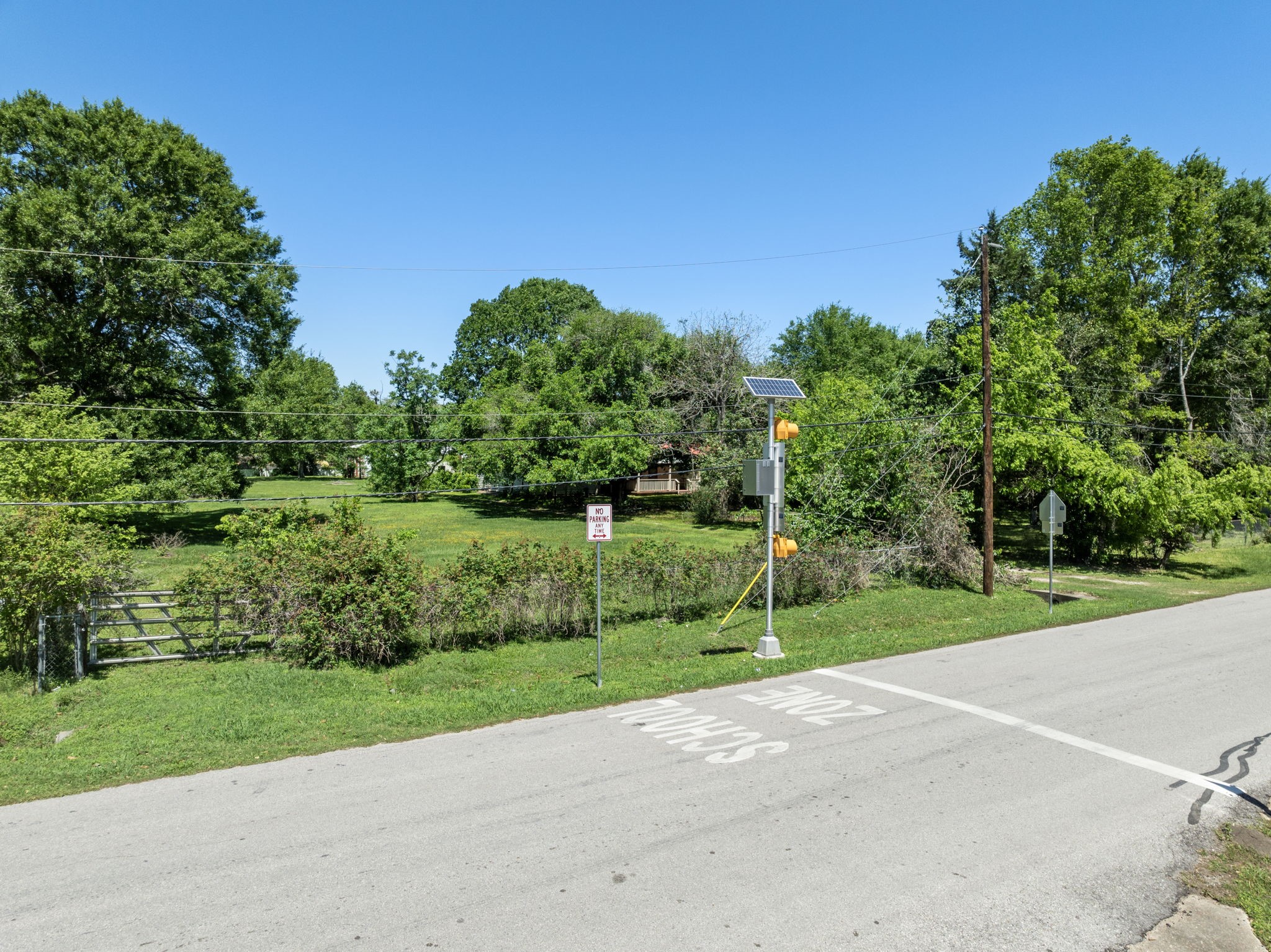 903 Brooks Avenue Rosenberg, TX 77471 - Photo 6 of 11 Positioned across from a designated school zone, the lot sits in a developed area with utility access and surrounding residential structures.