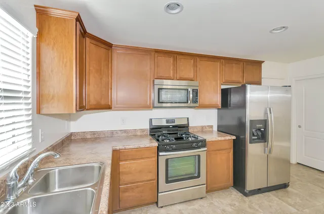 a kitchen with stainless steel appliances granite countertop a refrigerator stove and sink