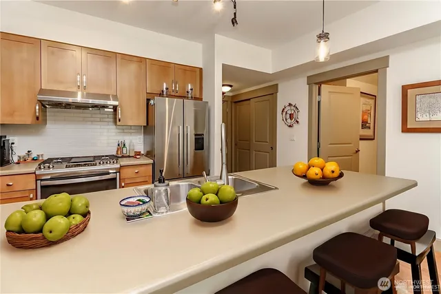 a kitchen with a refrigerator a sink and cabinets