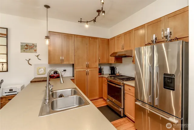 a kitchen with stainless steel appliances granite countertop a refrigerator and a stove
