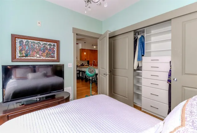 a view of a kitchen with refrigerator and wooden floor