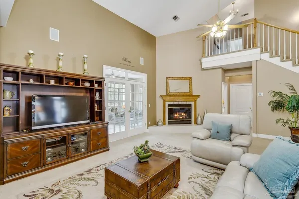 a living room with furniture a flat screen tv and a fireplace