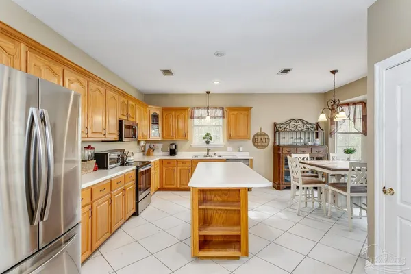 a large kitchen with cabinets wooden floor and stainless steel appliances