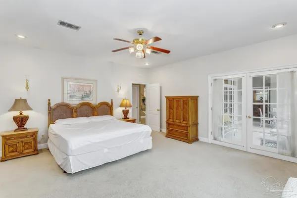 a spacious bedroom with a bed and dresser