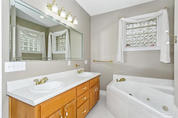 a bathroom with a tub sink and mirror