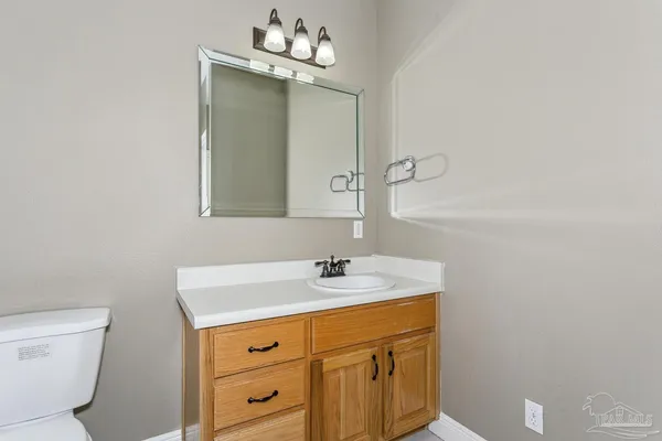 a bathroom with a sink a toilet and a mirror