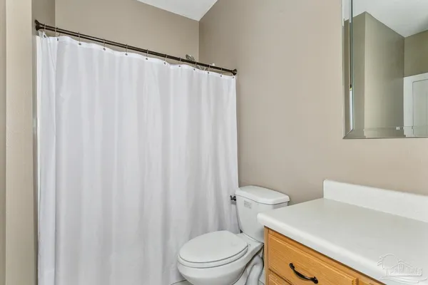 a white toilet sitting next to a white sink and curtain