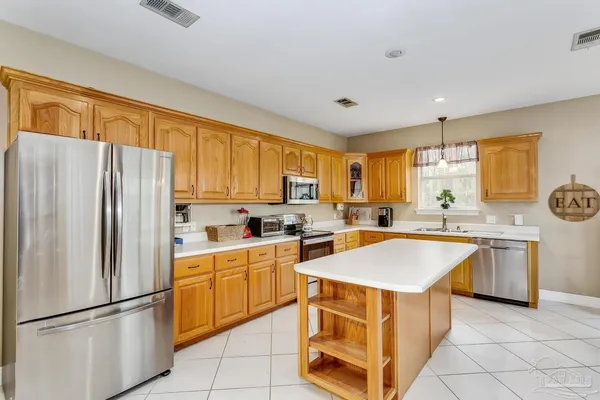a kitchen with stainless steel appliances granite countertop a refrigerator sink and stove