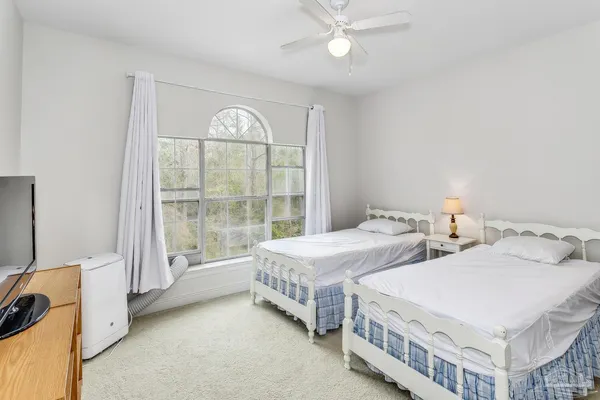 a bedroom with two beds and a chandelier