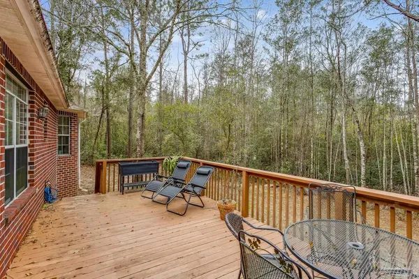 a view of roof deck with chairs and wooden fence