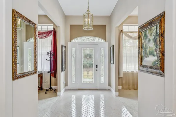 a view of a hallway with windows and chandelier