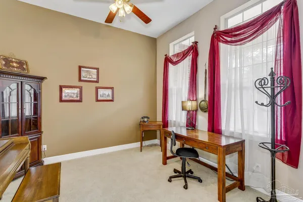 a view of a workspace with furniture and a window