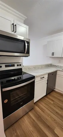 a kitchen with stainless steel appliances a stove microwave and cabinets