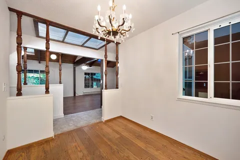 a kitchen with granite countertop stainless steel appliances white cabinets granite counter tops and a wooden floors