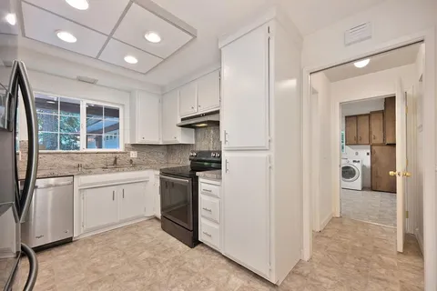 a kitchen with granite countertop a stove and a refrigerator