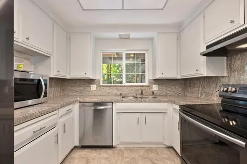 a kitchen with stainless steel appliances a refrigerator stove and cabinets