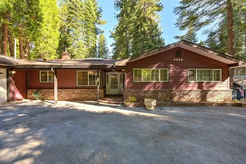 a view of an empty room with wooden floor and a fireplace