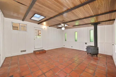 an empty room with a ceiling fan and window