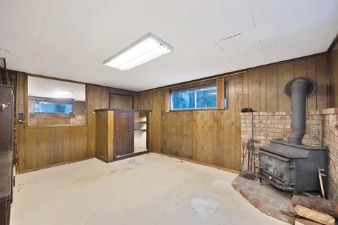 a view of a brick house next to a yard with large trees