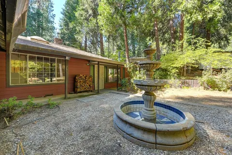 a view of a house with a yard and large tree