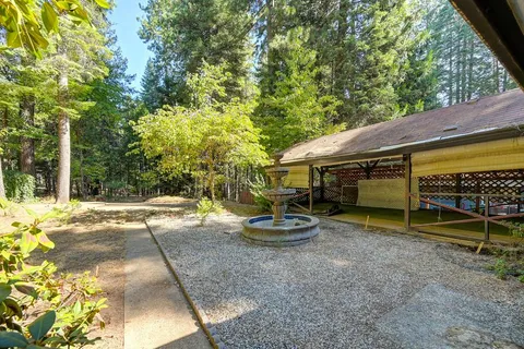 a view of a house with a garage and large trees