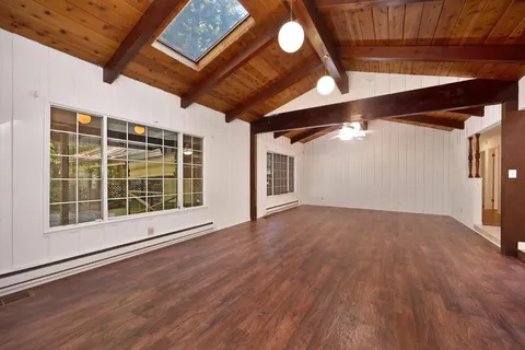 a view of a room with windows and wooden floor