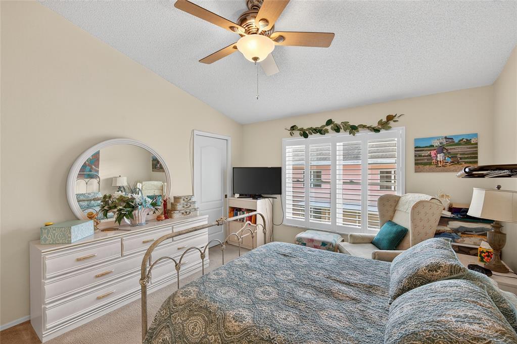 2292 Austrian Lane, Unit 26 Clearwater, FL 33763 - Photo 13 of 27 a bedroom with furniture a chandelier and a window