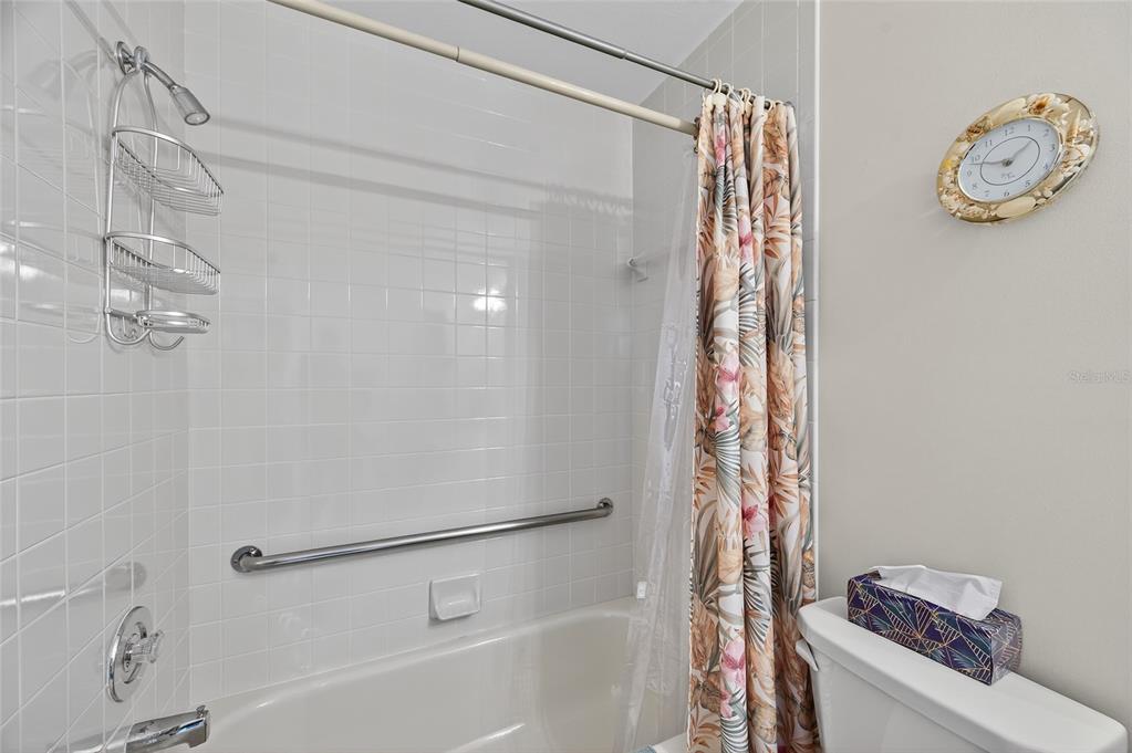 2292 Austrian Lane, Unit 26 Clearwater, FL 33763 - Photo 19 of 27 a bathroom with a shower curtain and a sink