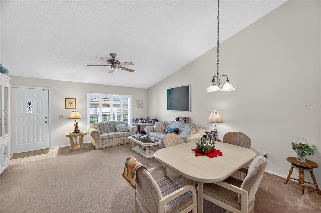 2292 Austrian Lane, Unit 26 Clearwater, FL 33763 - Photo 6 of 27 a living room with furniture and a chandelier